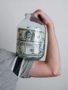 man holding big glass jar with money banknotes on hand. finance power and stability concept. moderate consumption and