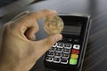 Man holding a Bitcoin coin with a POS terminal on background. Bitcoins Cryptocurrency. E-commerce, business, finance Royalty Free Stock Photo