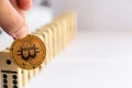 Man holding bitcoin and destroying the row of dominos. Royalty Free Stock Photo