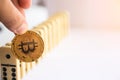 Man holding bitcoin and destroying the row of dominos. Royalty Free Stock Photo