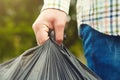 Man holding black plastic bag with trash Royalty Free Stock Photo