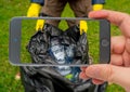 Man holding black plastic trash bag with empty plastic bottles. Photo smartphone. Royalty Free Stock Photo