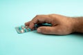 Man holding blister of pills