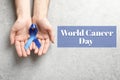 Man holding blue ribbon on background, top view. World Cancer Day Royalty Free Stock Photo