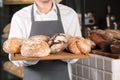 Man holding board with assortment of fresh bread in bakery Royalty Free Stock Photo