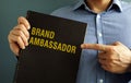 Man holding book with title Brand Ambassador. Royalty Free Stock Photo