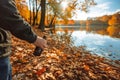 man holding a bottle found among autumn leaves, lake and trees in autumn colors Royalty Free Stock Photo