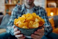 A man is holding a bowl of chips and smiling.ai geneative