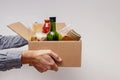 Man holding a box full on canned and packed foodstuff