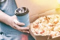 Man is holding box with tasty pizza and paper cup with drink, close up. Fast food for lunch. Snack on a sunny summer day Royalty Free Stock Photo