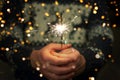 Man is holding bright festive Christmas sparkler in hand. Royalty Free Stock Photo