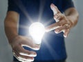 Man holding bright shining light bulb represents a new idea, thought, invention, innovation, solution, creativity, technology, and Royalty Free Stock Photo