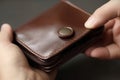 Man holding brown leather wallet with zip. Generate ai