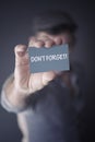 Man holding business card with words Dont Forget