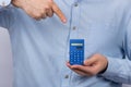 Man holding calculator and shows finger at him. Calculation of budget, savings, tax calculation
