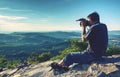 Man holding camera at eyes on mountain