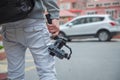 An unidentified man holding gimbal a camera stabilizer . Man holding gimbal stabilizer outdoor. Gimbal Operator with black Royalty Free Stock Photo