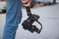 An unidentified man holding gimbal a camera stabilizer . Man holding gimbal stabilizer outdoor. Gimbal Operator with black Royalty Free Stock Photo