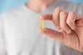 Man holding capsules with omega 3, vitamin D in hand. Nutritional supplement with fish oil. Health support and treatment Royalty Free Stock Photo