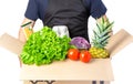 Man holding a carton box with lettuce, tomato and spaghetti, pineapple isolated on white Royalty Free Stock Photo