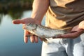 Man holding caught fish at lake, Royalty Free Stock Photo