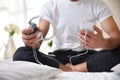 Man holding a cellphone and headphones sitting with legs crossed Royalty Free Stock Photo