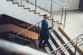 Man holding cellular in hand and walking on stairs