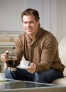 Man holding coffee carafe pouring cup of coffee