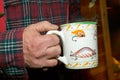 Man holding a coffee mug decorated with lures Royalty Free Stock Photo