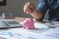 man holding a coin to drop a piggy bank For saving money for the future of the family, saving ideas Royalty Free Stock Photo