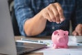 man holding a coin to drop a piggy bank For saving money for the future of the family, saving ideas Royalty Free Stock Photo