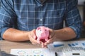 man holding a coin to drop a piggy bank For saving money for the future of the family, saving ideas Royalty Free Stock Photo