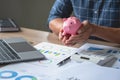 man holding a coin to drop a piggy bank For saving money for the future of the family, saving ideas Royalty Free Stock Photo