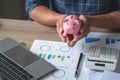 man holding a coin to drop a piggy bank For saving money for the future of the family, saving ideas Royalty Free Stock Photo