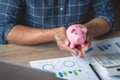 man holding a coin to drop a piggy bank For saving money for the future of the family, saving ideas Royalty Free Stock Photo