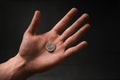 Man holding a coins. Euro currency on a black background. HandÃÂ´s of young man holding a money. Finance and banking concept.