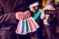 Man holding colorful shopping bags on the dark city background Royalty Free Stock Photo