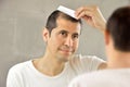 Man looking himself fresh at the mirror Royalty Free Stock Photo