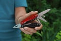 Man holding compact portable multitool outdoors, closeup Royalty Free Stock Photo