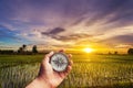 A man holding compass on hand at field and sunset for navigation Royalty Free Stock Photo