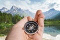 Man is holding compass in hand. Hiking and tourism concept. Mountains in background Royalty Free Stock Photo