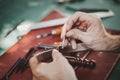 Man holding crafting tool and working. He is sewing hammer to make a wallet Royalty Free Stock Photo