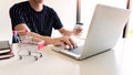 Man holding credit card in hand and entering security code using smart phone on laptop keyboard, online payment shopping concept Royalty Free Stock Photo