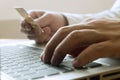 Man holding credit card and using laptop for shopping online