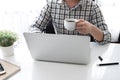 Man is holding a cup of coffee while working with laptop computer in the morning Royalty Free Stock Photo