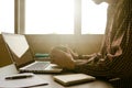 A man holding a cup of coffee and working on laptop in offic