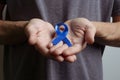 Man holding dark blue ribbon. Awareness ribbon
