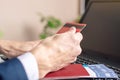 Man holding debit card in hand buying on the Internet airline tickets using a laptop. Purchasing and booking online Royalty Free Stock Photo