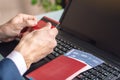 Man holding debit card in hand buying on the Internet airline tickets using a laptop. Purchasing and booking online Royalty Free Stock Photo