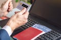 Man holding debit card in hand buying on the Internet airline tickets using a laptop. Purchasing and booking online Royalty Free Stock Photo